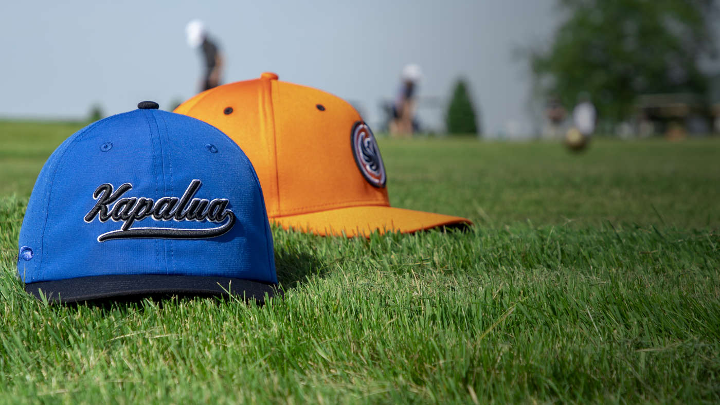 Pukka Juniors hats sitting on a putting green