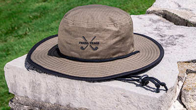 Bucket Golf sun hat on a stone wall