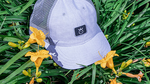 Pukka Ladies Golf Hat in a flower bed