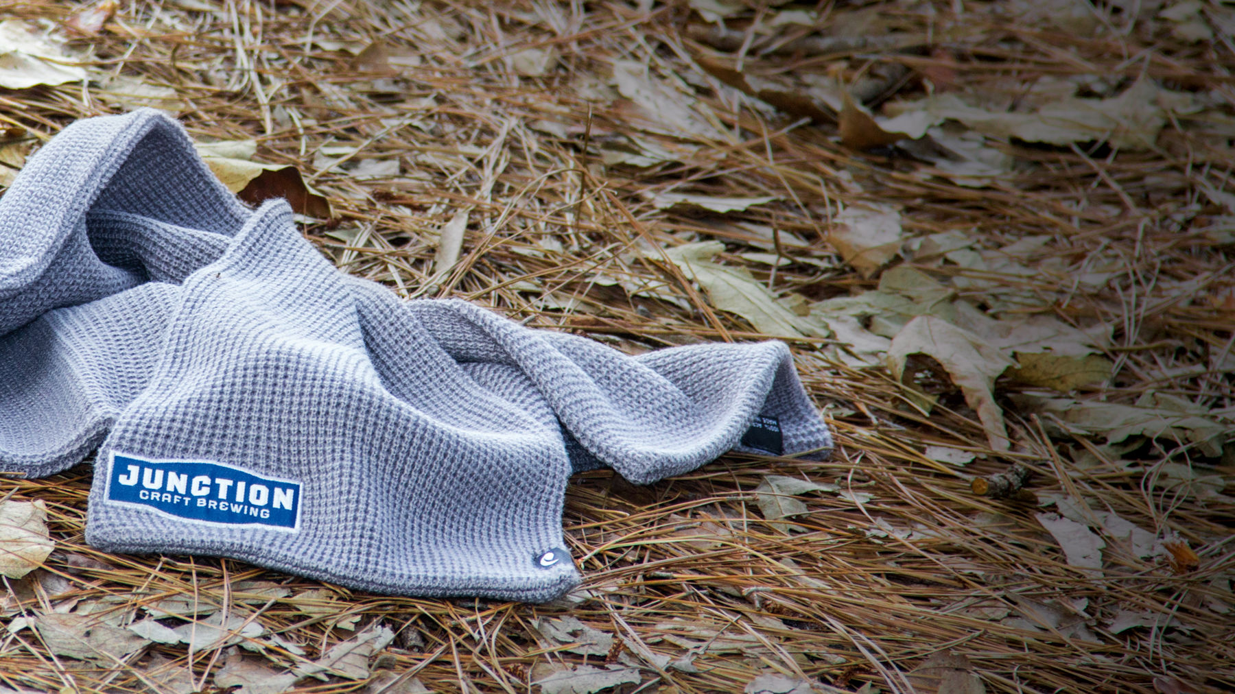 Scarf laying on pine needles and leaves