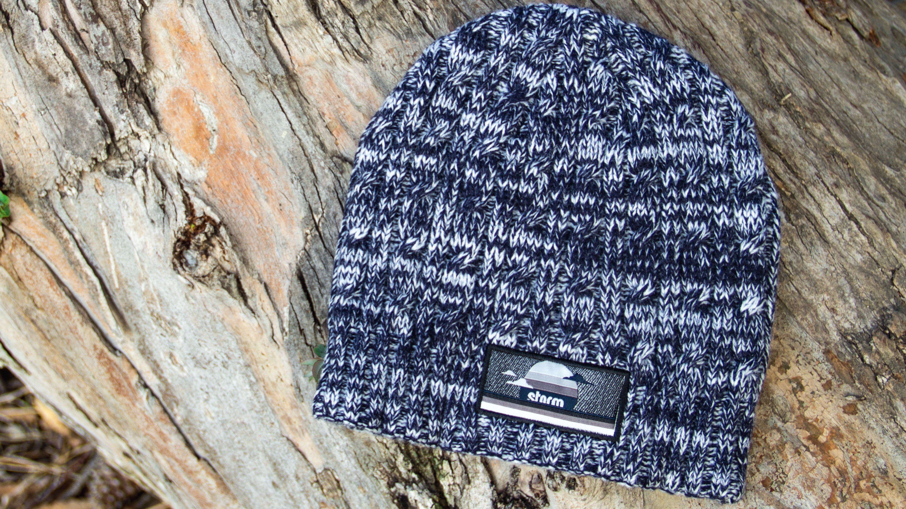 Cable Knit laying on a wood log